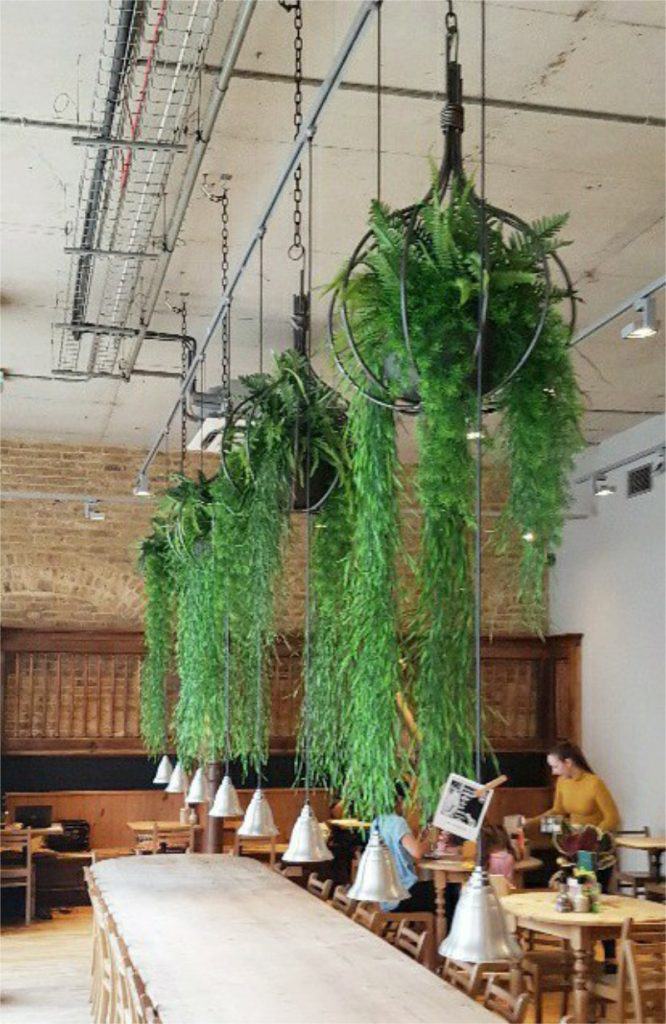 Hanging bespoke hanging onion shape baskets filled with artificial ferns for restaurant
